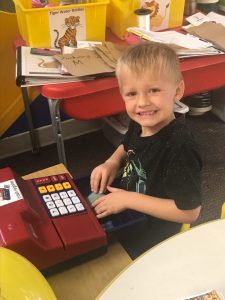child sitting at play cash register 